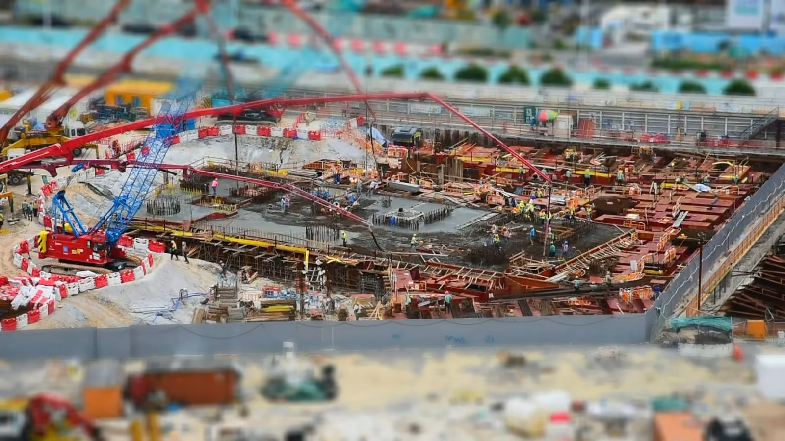 Still from a construction time-lapse showing concrete pumps, foundations and activity across a site