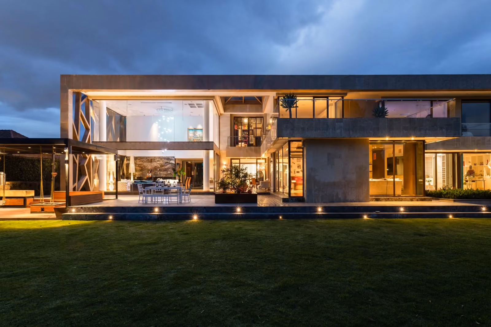Completed contemporary building at dusk with warm interior lighting and glass facades
